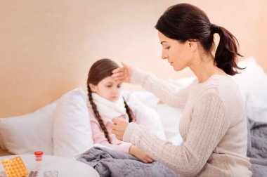 Ciddi kadın kızı alnına dokunmak