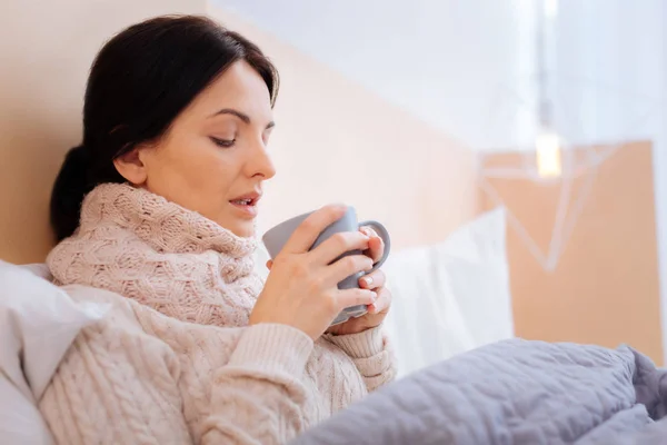 Mujer enferma cansada mirando su taza — Foto de Stock