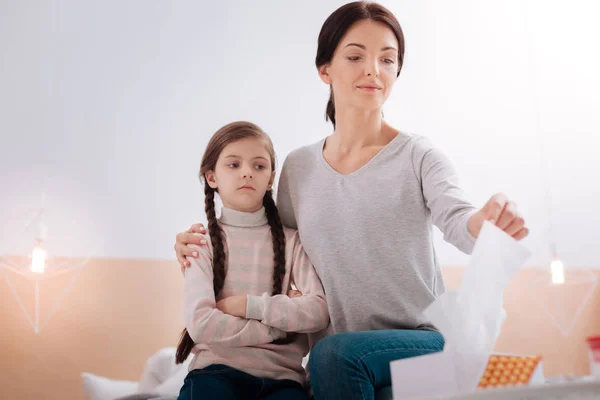Serious child sitting with a smiling woman — Stock Photo, Image
