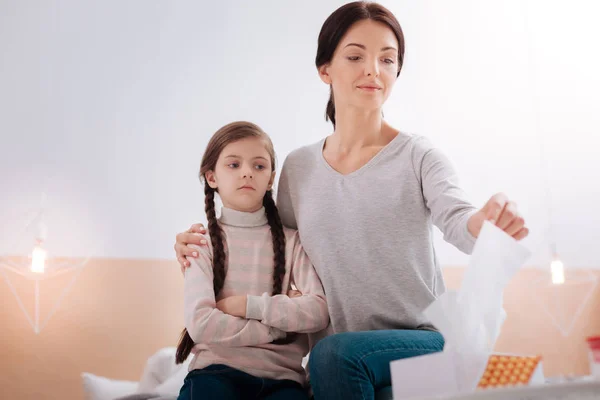 Niño serio sentado con una mujer sonriente — Foto de Stock