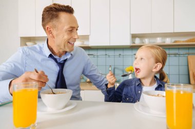 Bir kaşık tutan sevimli genç kız