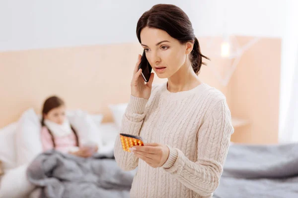 Bertanggung jawab ibu berkonsultasi tentang pil di telepon — Stok Foto