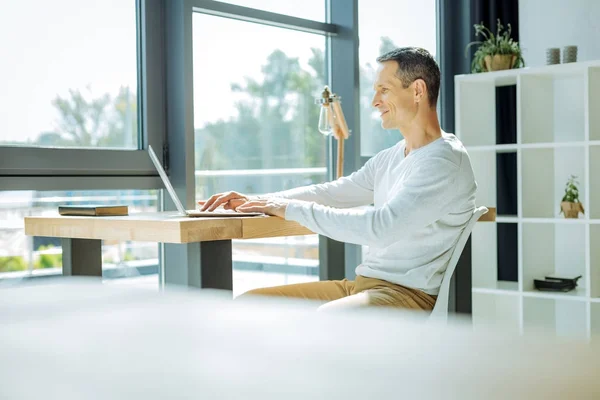 Positieve vrolijke man aan het werk in zijn kantoor — Stockfoto