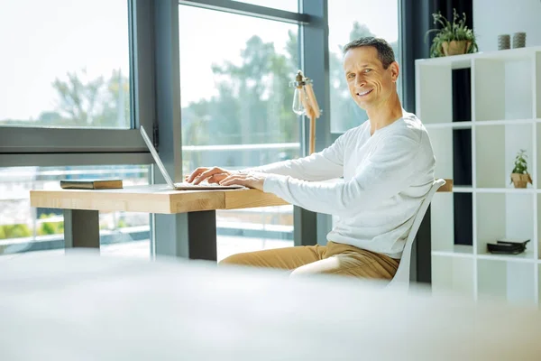 Delighted attractive man looking at you