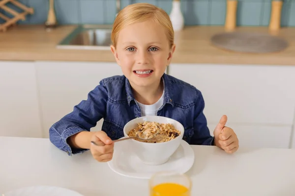 Joyful young girl eating healthy breakfast — Stock Photo, Image