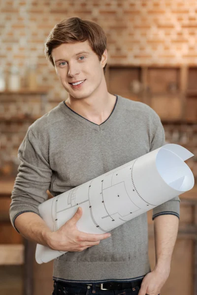 Cheerful man holding blueprint and smiling — Stock Photo, Image