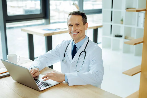 Przystojny inteligentny lekarz za pomocą laptopa — Zdjęcie stockowe