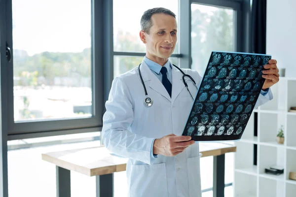 Encantado neurólogo inteligente sosteniendo un escáner de rayos X —  Fotos de Stock