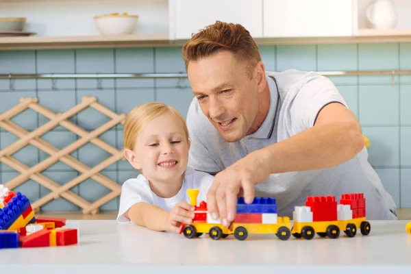 Bom pai alegre olhando para o trem de brinquedo — Fotografia de Stock