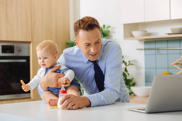 Angenehmer netter Mann mit Blick auf den Laptop-Bildschirm — Stockfoto