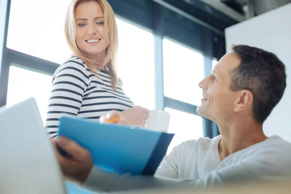 Glückliche blonde Frau schaut auf den blauen Ordner — Stockfoto