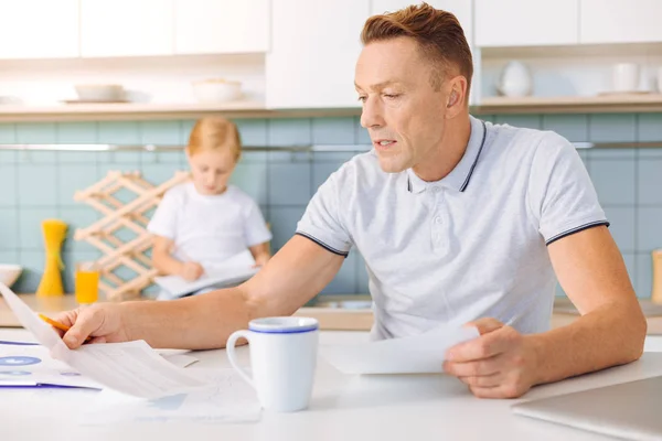 Sério homem infeliz lendo um documento — Fotografia de Stock