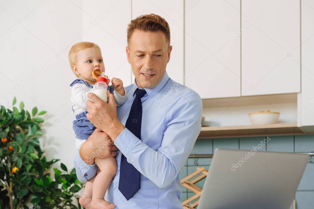 Pleasant caring father feeding his daughter