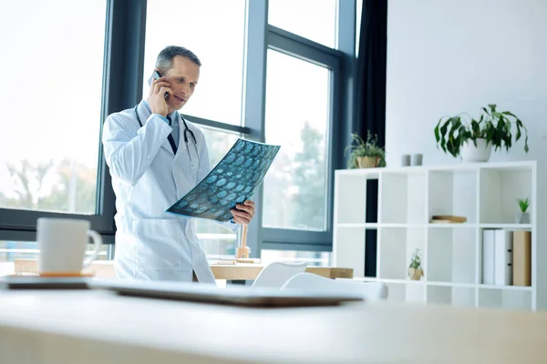 Agradável médico inteligente fazendo uma chamada — Fotografia de Stock