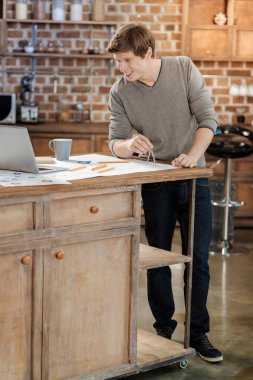 Pusula kullanarak ve öğretici video izlerken neşeli adam