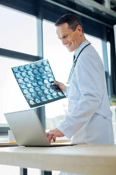 Radiologista bonito alegre usando um laptop — Fotografia de Stock