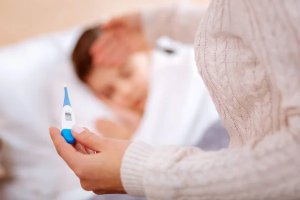 Thermomètre coloré entre les mains d'une jeune femme — Photo