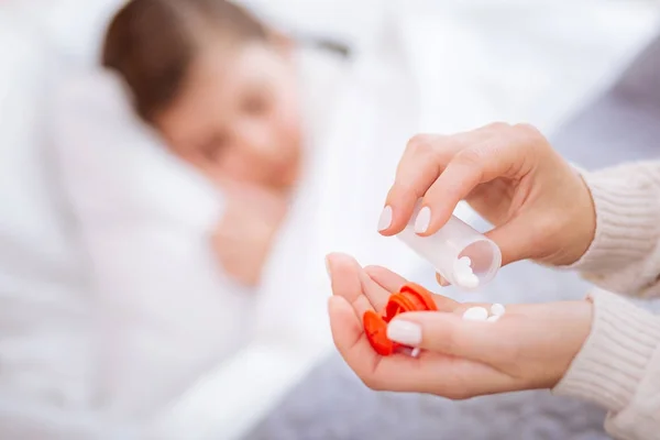 Attente verantwoordelijk vrouw tellen de pillen in haar hand — Stockfoto