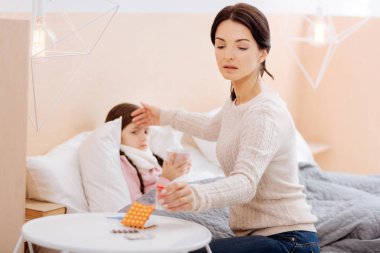 Endişeli anne bir makinelinin masanın üzerine koyarak