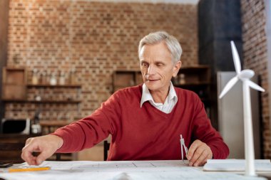 Kalem almak için elini ulaşan kıdemli mühendis gülümseyen
