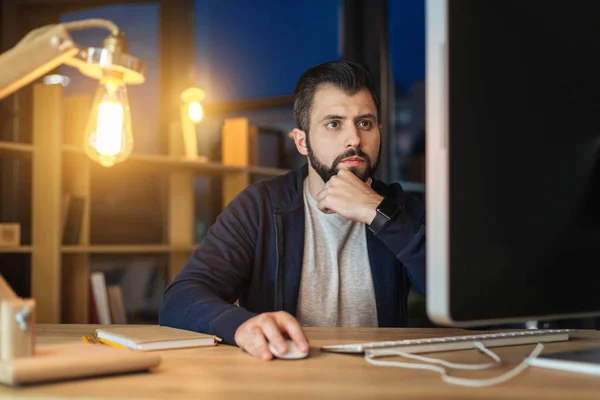 Programador concentrado que está en la oficina por la noche — Foto de Stock