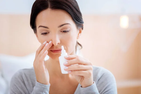 Sad woman curing her allergy with a help of nasal drops — Stock Photo, Image