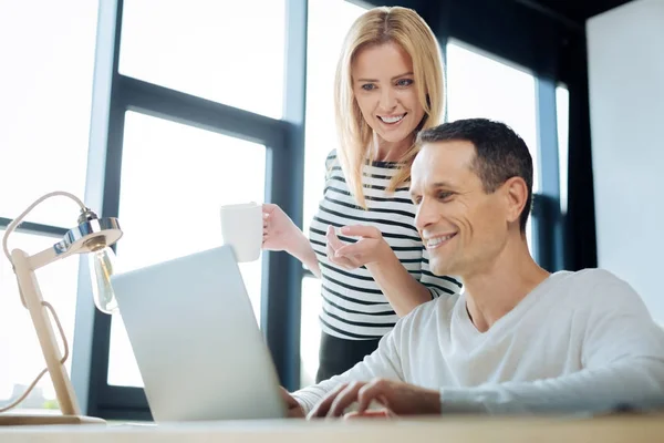 Delighted positive woman pointing at the laptop screen