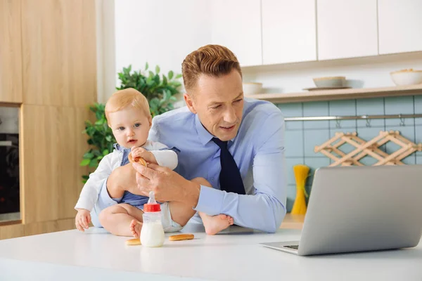 Agradable hombre adulto de pie delante de la computadora portátil —  Fotos de Stock