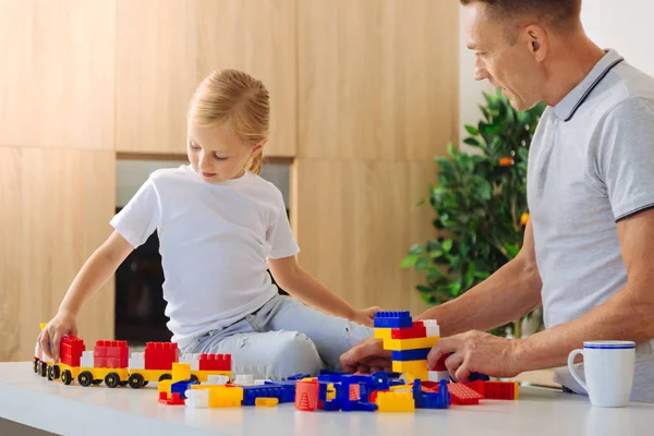 Encantada menina agradável jogando com um trem de brinquedo — Fotografia de Stock