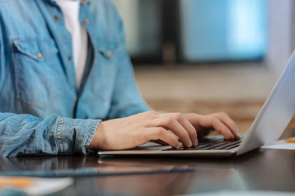 Close up de homem de camisa jeans digitando no laptop — Fotografia de Stock