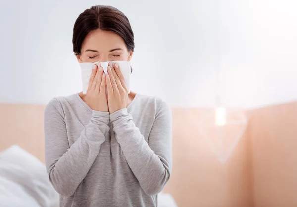 Allergic woman pressing a napkin to her nose — Stok fotoğraf