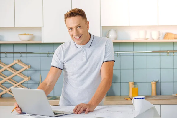 Vrolijke aardige man, staande voor de laptop — Stockfoto