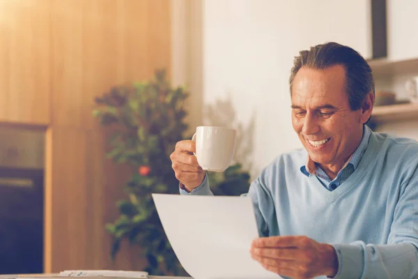 Позитивный зрелый бизнесмен читает дома документ — стоковое фото