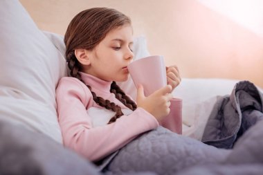 Çok hasta kız büyük bir fincan sıcak çay içme
