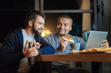 Yarı pozisyonda oturan memnun sakallı adam