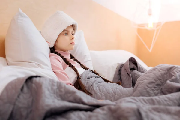 Unemotional girl with a towel on her forehead — Stock Photo, Image