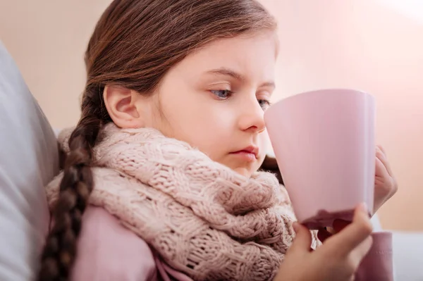 Little girl with a cup looking upset — Stock Photo, Image