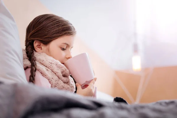 Sad girl with bunches drinking tea — Stock Photo, Image