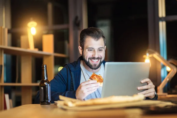 Schöner Mann lächelt beim Essen — Stockfoto