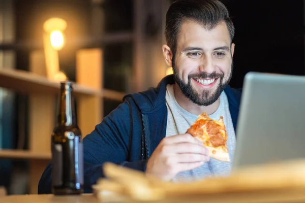 Relaxed male person eating pizza