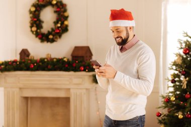 Gülümseyen adam Noel Baba şapkası ile selamlar iletileri okuma