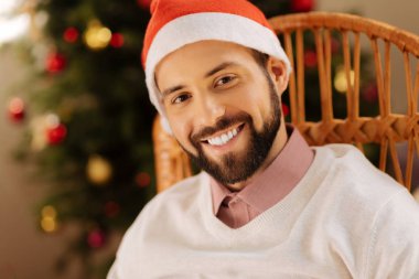 Noel Baba şapkası kameraya gülümseyen yakışıklı adam