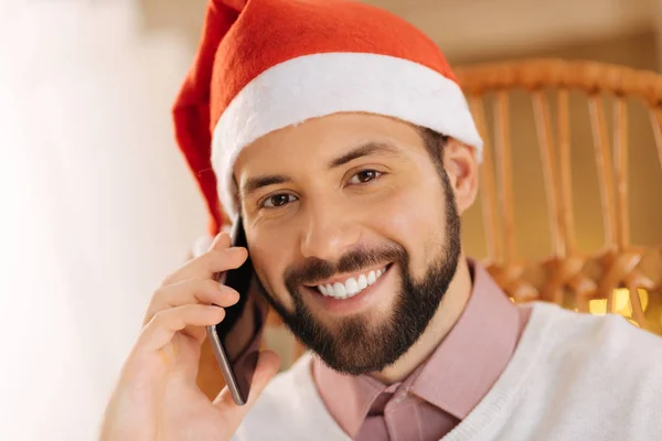 Портрет улыбающегося человека в шляпе Санты, делающего телефонные звонки — стоковое фото