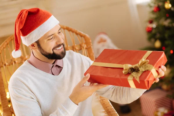 Счастливый человек рассматривает подарочную коробку в своих руках — стоковое фото