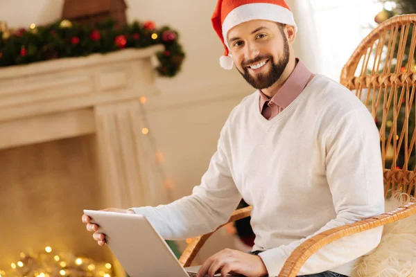 Kellemes ember Santa kalapban pózol a laptop — Stock Fotó