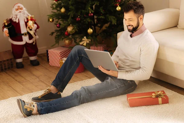 Aangename man surfen op het web zittend op de vloer — Stockfoto