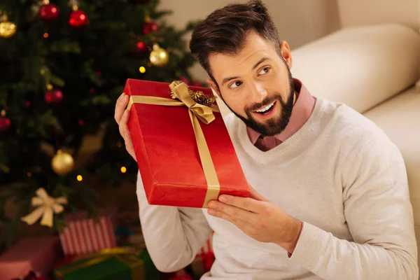 Счастливый человек слушает звук в подарочной коробке — стоковое фото