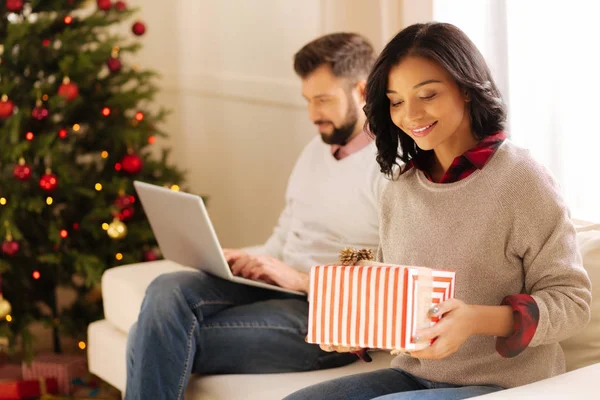 Hediye kutusu dizüstü bilgisayarda çalışan adam tutan gülümseyen kadın