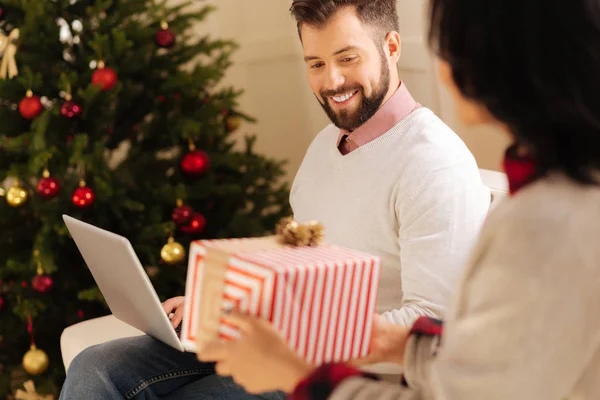 Femme aimante donnant son mari cadeau de Noël — Photo