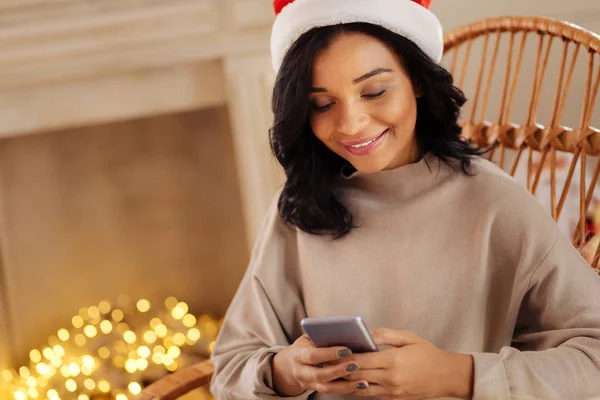 Mooie vrouw in Santa hat texting met man — Stockfoto